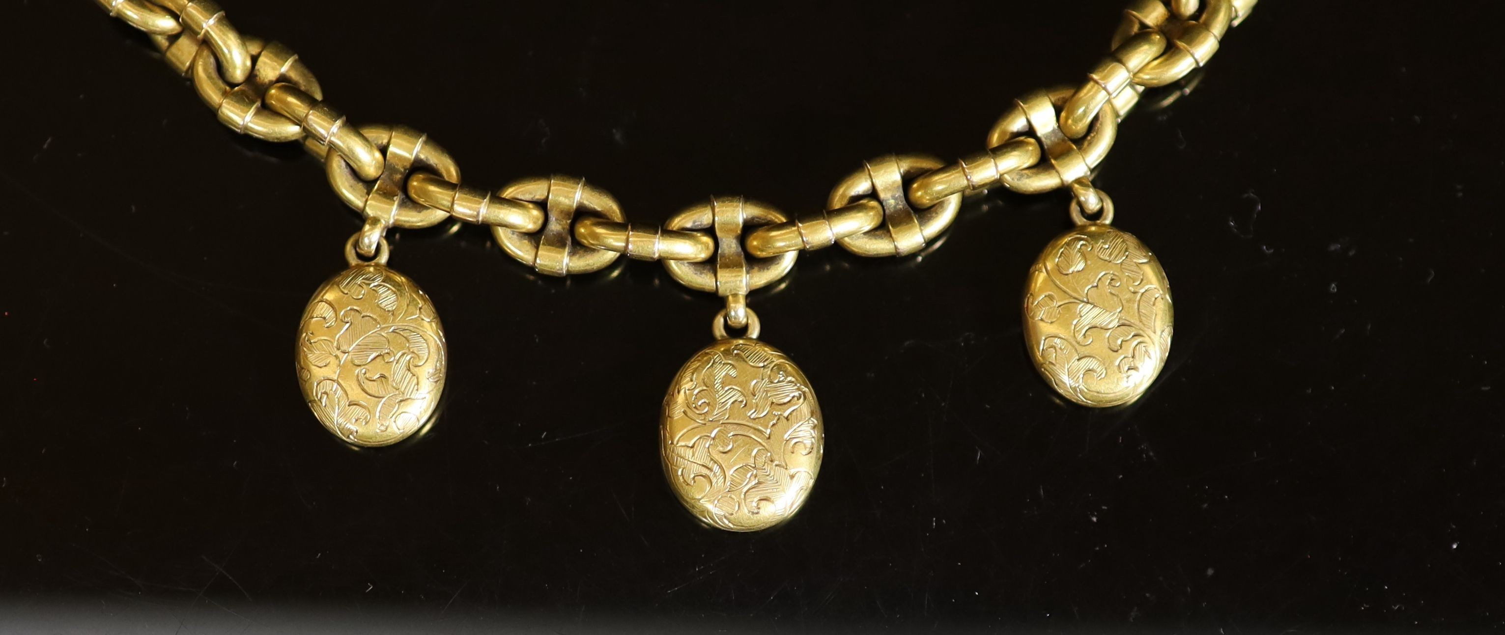 A Victorian gold oval link memorial bracelet, hung with three engraved oval charms, with glazed backs